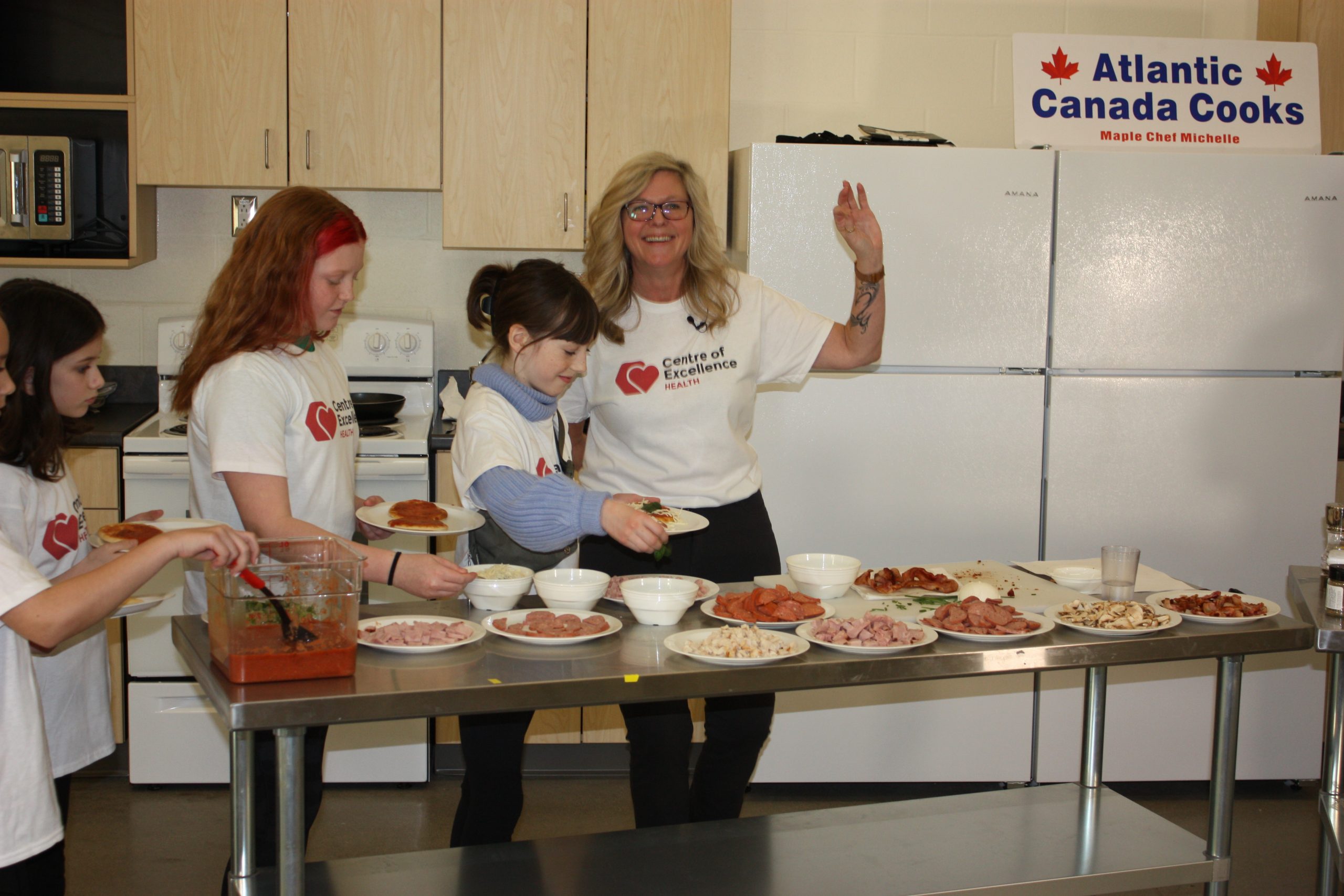 Michelle Alcorn, host of Atlantic Canada Cooks and president and CEO of Atlantic Canada Language Academy, giving students guidance on pizza toppings. On Wednesday, March 22, students at Hanwell Park Academy demonstrated their love of pizza by participating in a livestreamed pizza-making class. Thanks to the livestream, approximately 600 students within the province tuned in, as did students from 11 countries, and residents of two care homes.