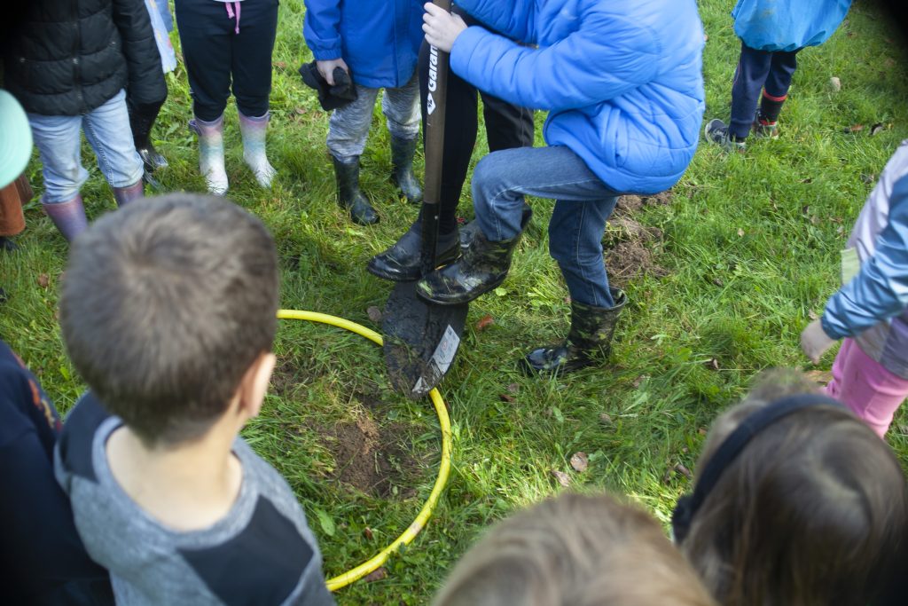 Kingsclear Community School students begin digging to plant a tree during Take Me Outside Day, Oct. 18, 2023.