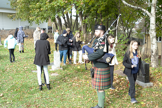 A piper plays as view headstones at the No Stone Left Alone ceremony at Oromocto's St. Vincent De Paul Cemetery, on Nov. 9, 2023.