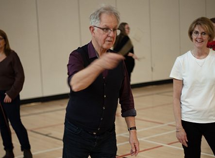 Canadian Playful Schools Network (CPSN) principal investigator Andy Hargreaves takes part in an Indigenous-origin game of skill as ASD-W Director of Curriculum and Instruction Dianne Kay looks on at the Playful Schools Atlantic Gathering in Education, Friday, Dec. 1, at Hanwell Park Academy.