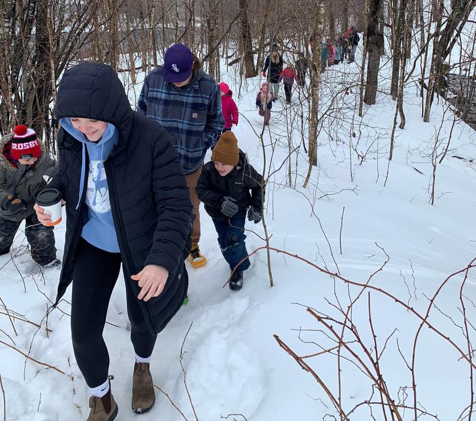 Students and staff at Stanley Consolidated School head out to trees on the school property to learn how to collect sap and make maple syrup, on March 27, 2024.
