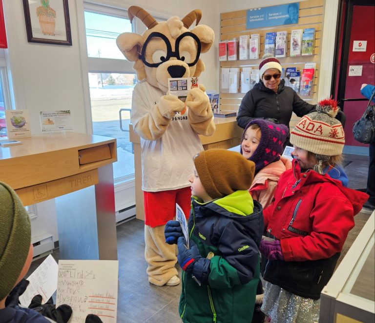 Bath Community School students, accompanied by Educational Assistant Krista Tibbetts, join our school mascot Mo in mailing their postcards at the post office in Bath on February 9.