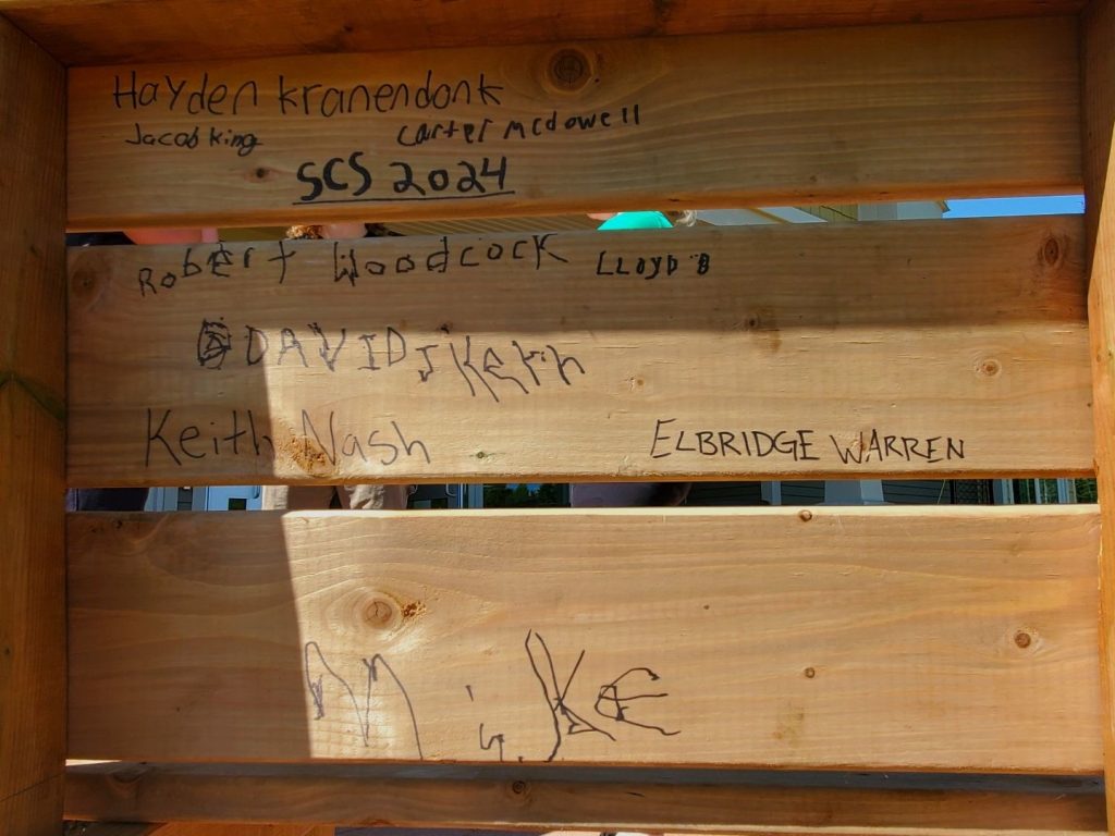 A bench, signed by Nashwaak Villa residents and Stanley Consolidated School Grade 12 students Hayden Kranendonk, Jacob King, and Carter McDowell. 