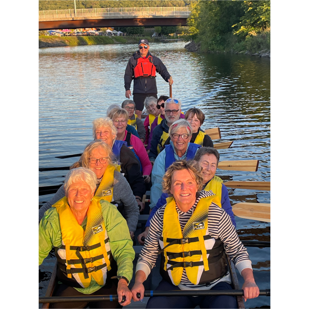 Senior dragon boat paddler Gloria Yachyshen  (third row right, in blue life vest) and her fellow paddlers enjoy their time on the Meduxnekeag River.