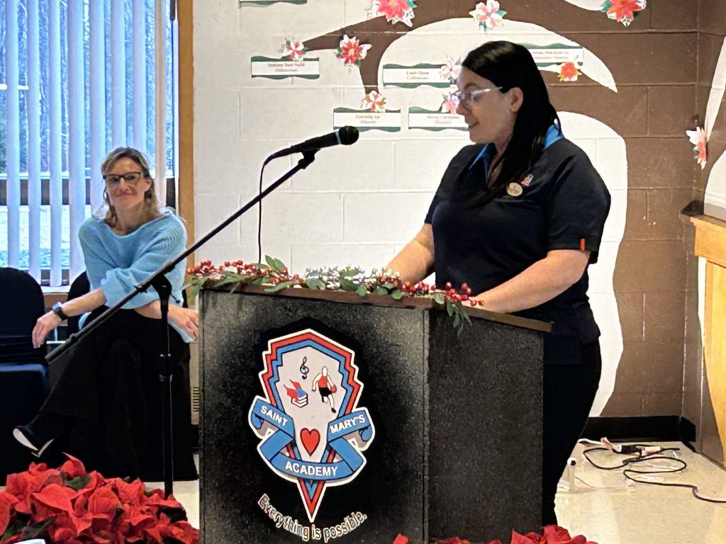 SMA Principal Julie Michaud looks on as PSSC chairperson Shirley Pelletier addresses the audience at the unveiling ceremony for the refurbished Saint Mary's Academy playground on Friday, Nov. 22, 2024.