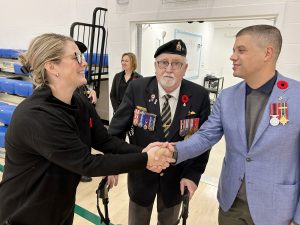 Cuffman Street Elementary Vice-Principal Mali Coulombe greets Royal Canadian Legion Branch 4 members Bob Griffin, center, and Noah Starr, right. Both men are veterans who attended the new school's first Remembrance Day ceremony, on Thursday, November 7, 2024.