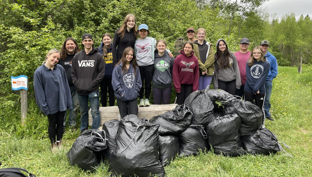 Nackawic High School students pose with bags of the invasive garlic mustard plant, and other invasive species, they removed from the Meduxnekeag Valley Nature Preserve in May. Photo Credit: MRA