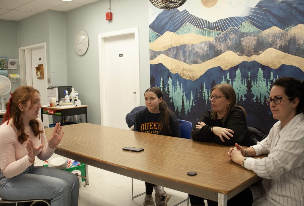 (L-R) Woodstock High School Grade 10 student Gracelyn Grant--the Planet Youth student club mentorship coordinator--discusses Planet Youth initiatives with McGuinness, Boone, and Shapiro.