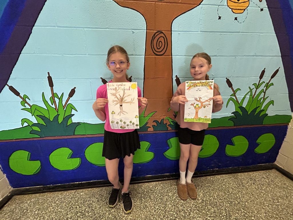 (L-R) Garden Creek School Grade 5 students Sydney Pearce and Lucy Spink show off the individual designs they drew which were combined to create the mural.