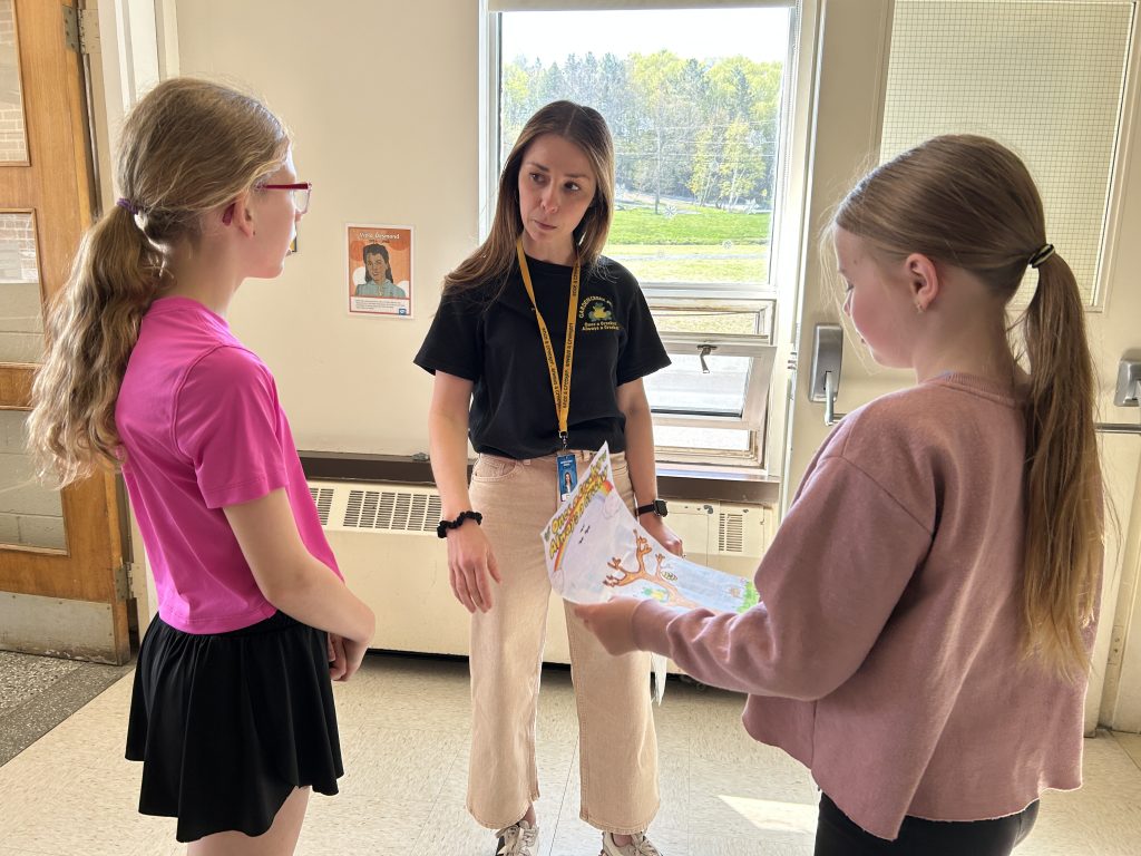 (L-R) Garden Creek School Grade 5 students Sydney Pearce and Lucy Spink, talk with their teacher Jacqueline Saunders (centre) about the mural they helped paint at the school.