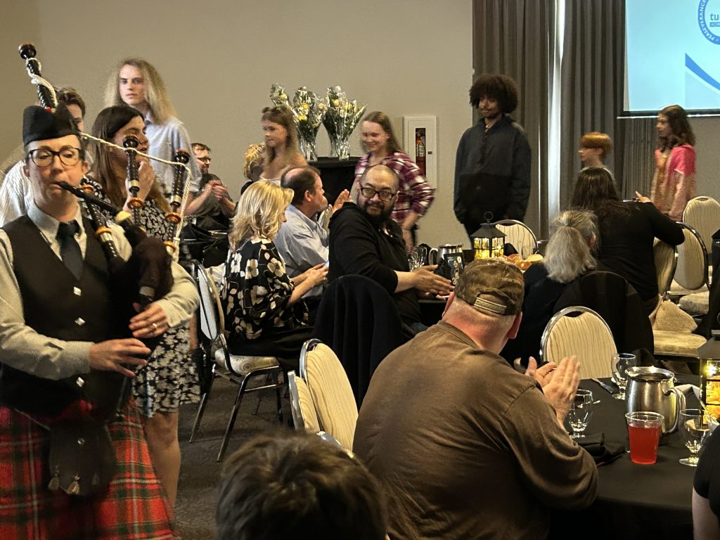 A piper leads Woodstock-area students in during the opening of the Craig Turnaround Achievement Awards ceremony at the Woodstock Best Western on Wednesday, May, 21.