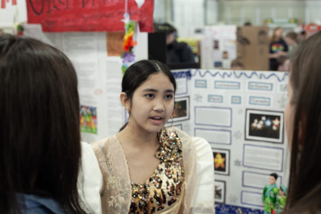 Fredericton High School Grade 9 student Elyssa Laxamana explains her Heritage Fair project to a team of judges.