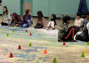Liverpool Street Elementary School Grade 2-5 students learn the history of treaties between Indigenous communities and colonial/Canadian governments with the help of a giant treaty map. The map enables students to "explore" the country to examine this history. Photo Credit: Katie Hoedl.