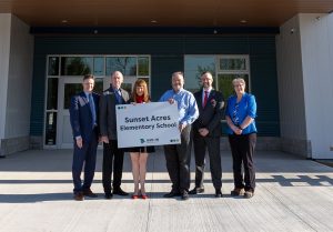 (L-R) David McTimoney, superintendent of Anglophone West School District; Thomas Geburt, chair of the district education council; Education and Early Childhood Development Minister Claire Johnson; Jason Burns, principal; Luke Randall, minister responsible for economic development and small business; and Darla Day, the district’s director of schools, in front of the district's newest school, Sunset Acres Elementary School. Photo Credit: GNB