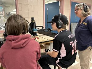 ASD-W Digital Learning Lead Wendy Thomas works with students at Cambridge-Narrows Community School to carve out a physical QR Code using an X-Carve machine.